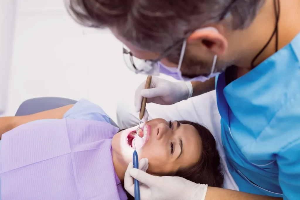 Dentist examining a patient’s teeth and gums before starting Invisalign treatment.