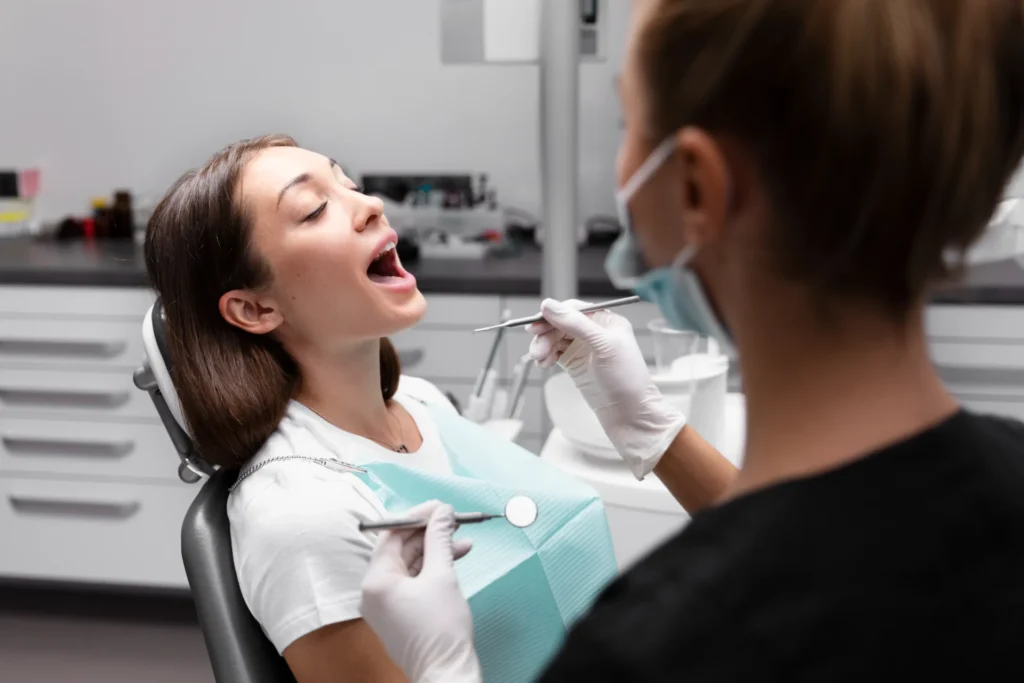 Dental professional checking a patient’s mouth during a hygiene appointment.