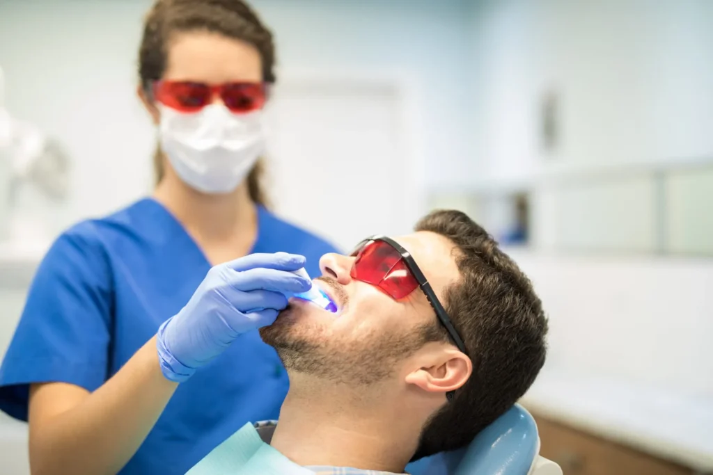 Patient receiving professional teeth whitening treatment in a dental clinic.